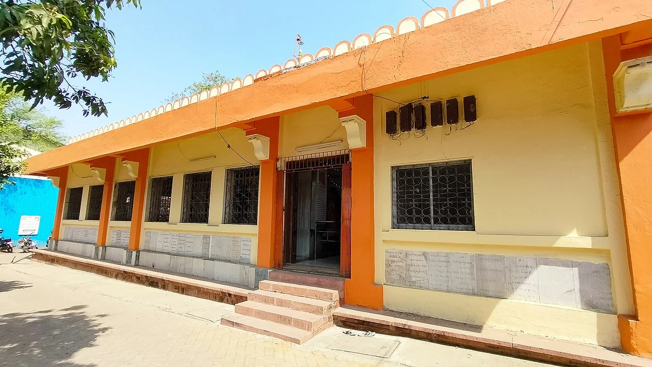 The yellow facade and side entrance of Varadvinayak Temple in Mahad