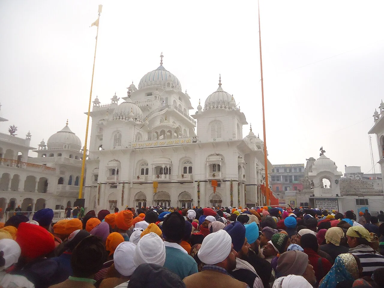 Devotees gathered in front of the white domes of Takht Sri Patna Sahib