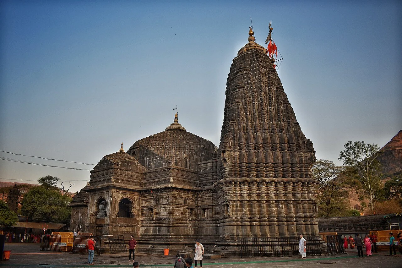 The dark carved stone spires of Trimbakeshwar Temple under the evening sky